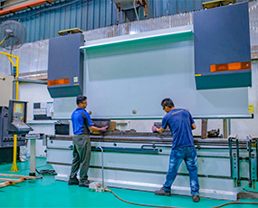 two men handling laser cutting machine to fabricate a metal sheet